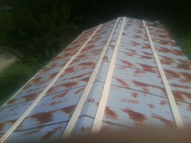 Rusted metal roof panels with new wood purlins before replacement — Storm Damage Roof Repair in Elton by Roofing Brothers