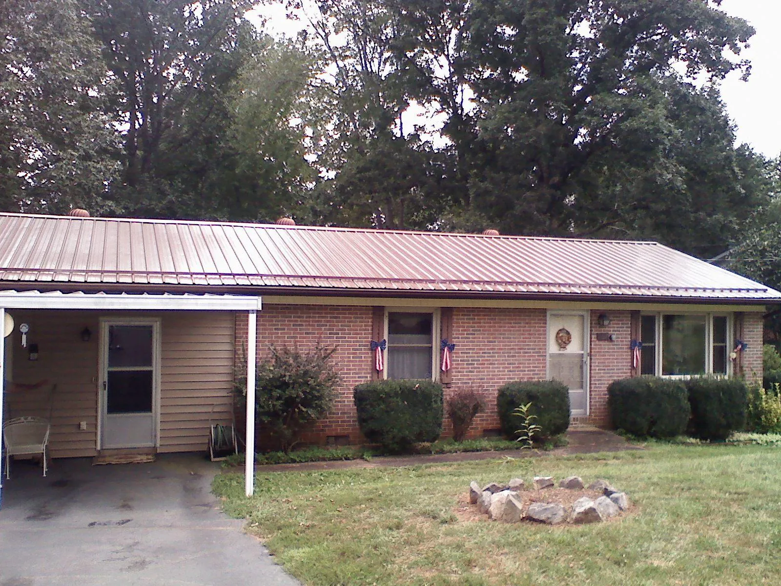Bronze metal roof and carport on a brick ranch home — Roof Repair work by our crew in Elton